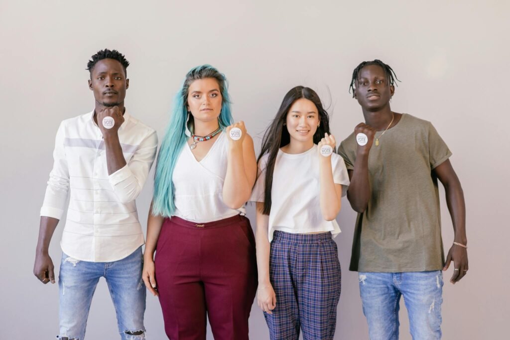 A diverse group of young adults holding 'Vote' badges, symbolizing political participation.